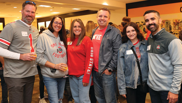 Six individuals standing together for a group photo while wearing their Buckeye gear