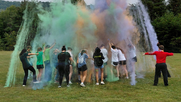 Large group of students with colorful powder flying in the air
