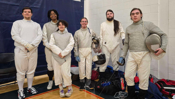Group of six students standing in fencing uniforms