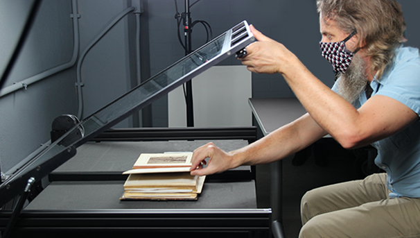 Briscoe Center staff digitizing a book.