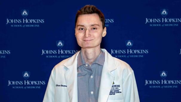 Ethan Neumann smiling in his white coat