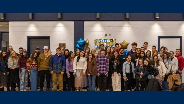 large group of students and community members posing for a group photo at an event