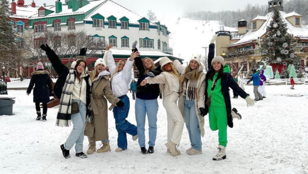 7 female students posing for a group photo in a snowy village