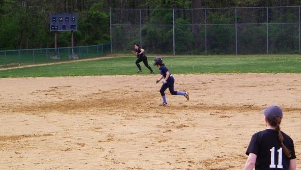 Softball player running to 3rd base