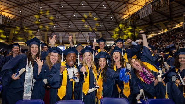 Group shot of graduates in the Skydome, in their caps, gowns, and stoles.