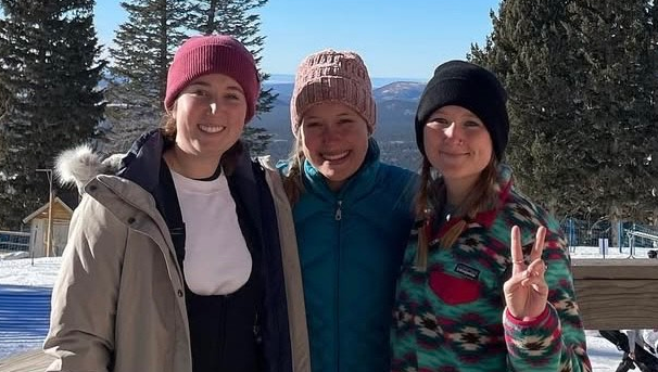Three Best Buddies Pine Pals club members at snow bowl posing in front of some pine trees.