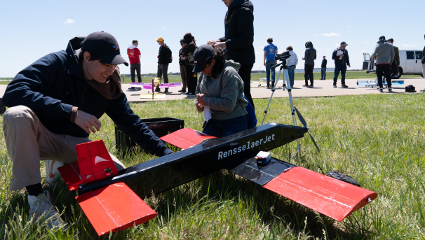 Students work on the plane at competition outdoors