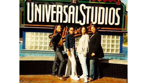 Four individuals posing in front of a Universal Studios Hollywood sign