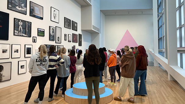 Group of students looking at a wall of art