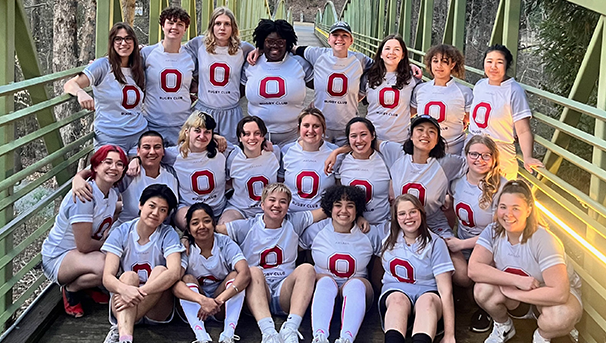 Ohio State Women's Club Rugby players on bridge in Savannah smiling for a group photo