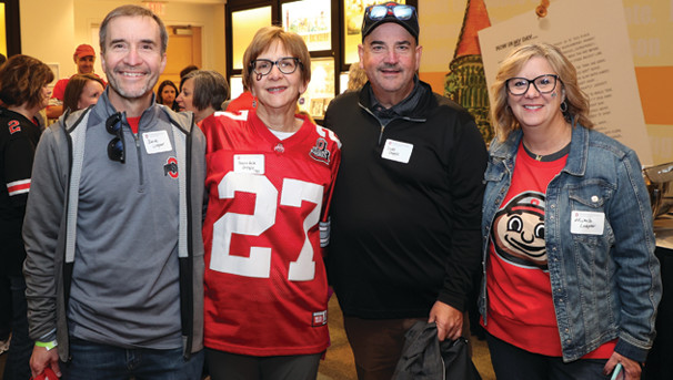 Four alumni smiling for a group picture