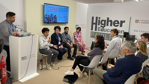 Students and faculty listen to a panel of individuals speaking at the conference