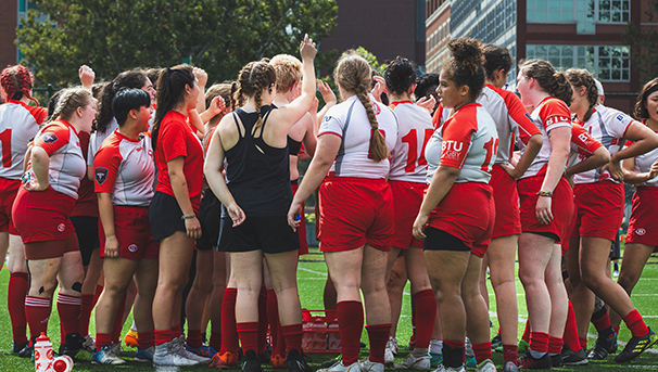 Ohio State Women's Club Rugby players and coaches huddled during game against Notre Dame