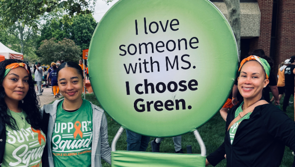 3 women with a sign that says "I love someone with MS. I choose Green."