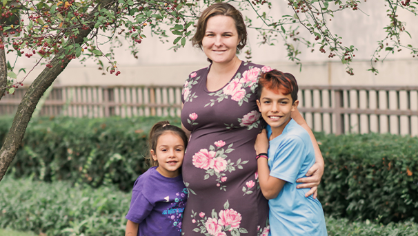 A mother with her two children: her daughter to her right and her son to her left