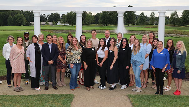 Group of people standing outside smiling for a photo