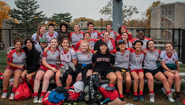 Ohio State Women's Club Rugby players sitting on bleachers smiling for a group photo in Indiana
