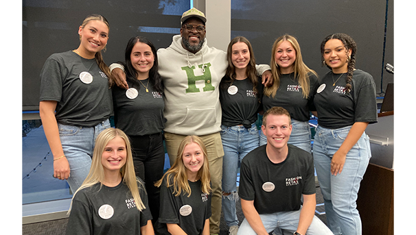Group of 9 people standing together smiling for a photo
