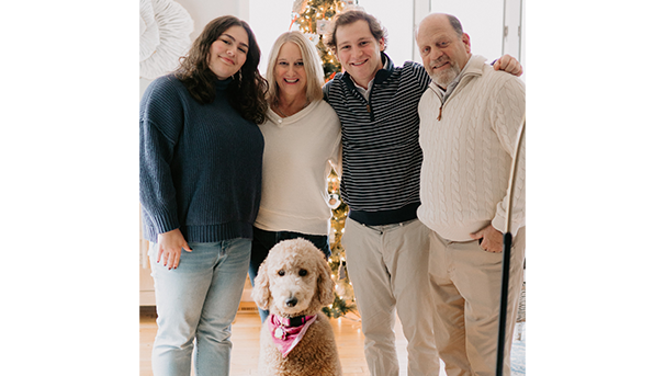 The Kline family standing in front of a Christmas tree with their dog