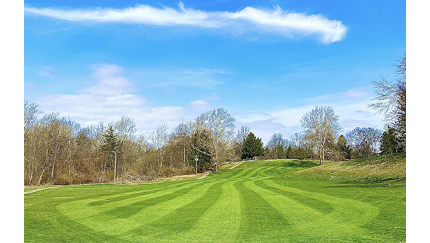 Image of golf course on a sunny day with clouds in the sky