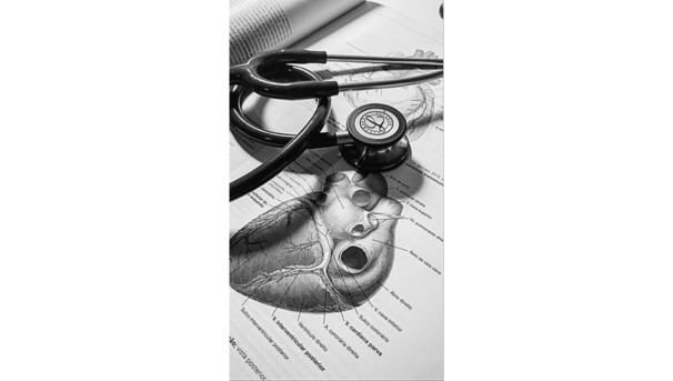 A stethoscope on an anatomy book open to a diagram of a heart