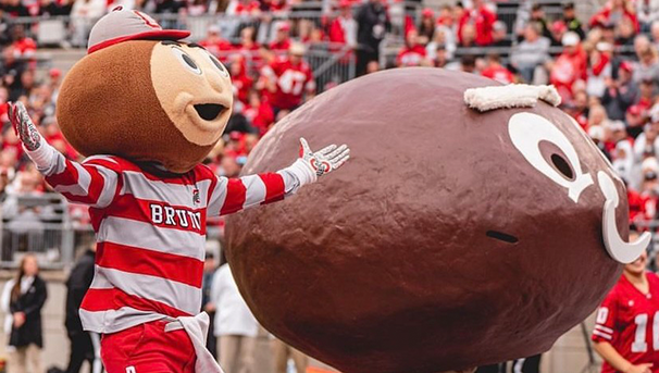 The new Brutus mascot standing on the field with the old Brutus mascot