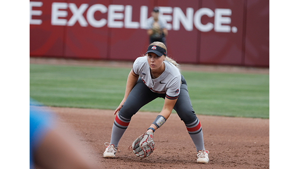 Ohio State softball player bending down to catch a softball on the field