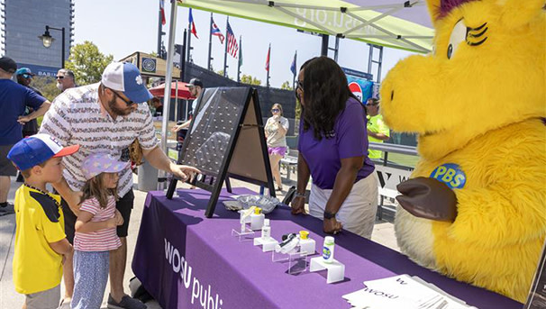Family at WOSU event table