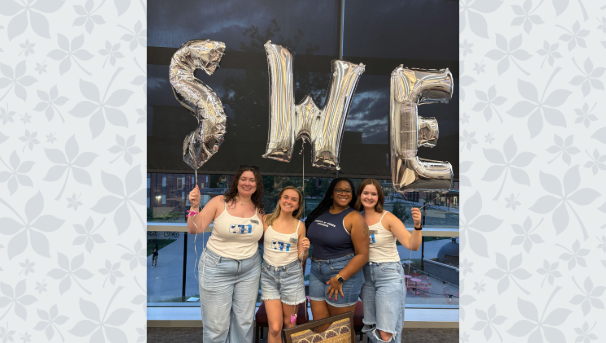 Members of the Society of Women Engineers pose together with SWE balloons