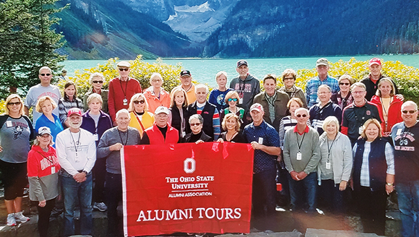 An alumni group before a large mountain