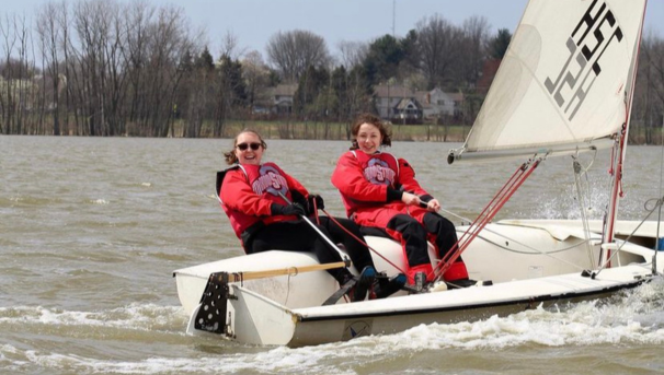 Two individuals on a sailboat in the water