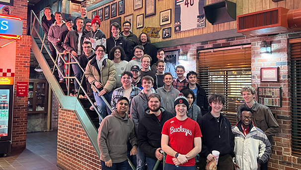 Men's Glee Club members standing on stairs at a restaurant