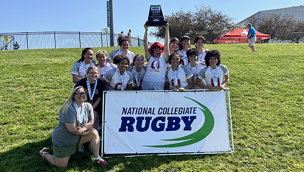 Women's Club Rugby players holding trophy and sign at National Collegiate Rugby 7s third place