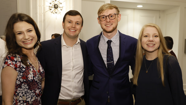 Four individuals pose together for a picture