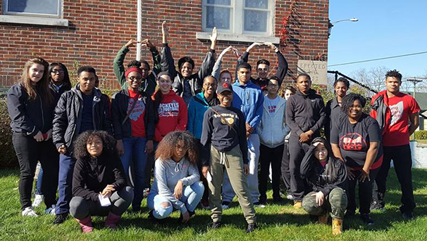 Group of individuals standing and kneeling outside for a photo