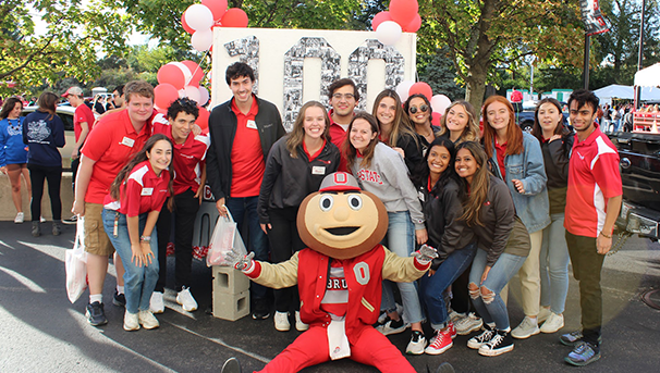 Group of individuals smiling for a photo outside during Homecoming parade