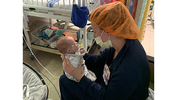 NICU nurse holding baby while in the hospital