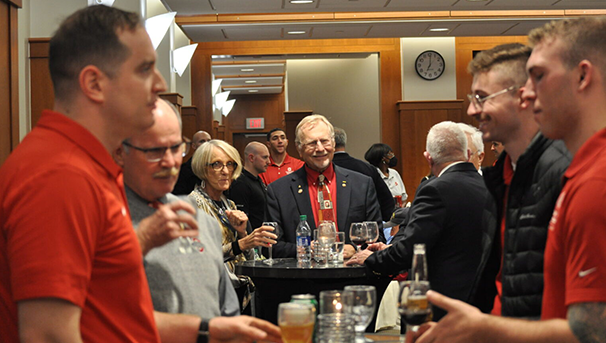 Group of individuals at a celebratory event standing by tables