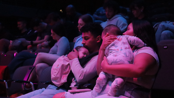 Two people sitting down holding babies