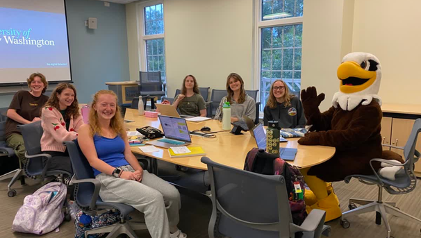 Group of students sitting in an HCC study room with Sammy D Eagle