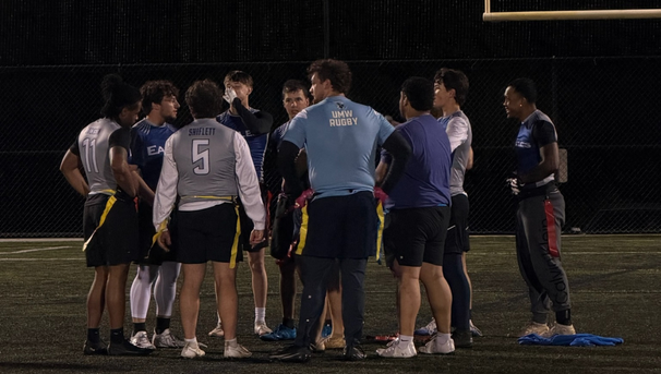 Group of football players in a circle on the field talking
