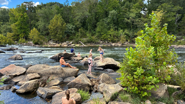 Group of students standing on rocks at a river