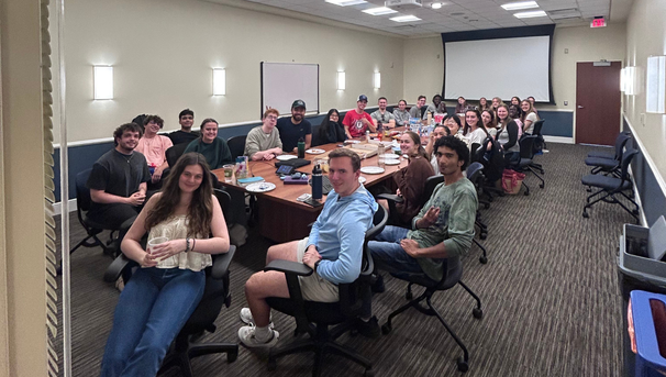 Large group of students sitting around a large conference table