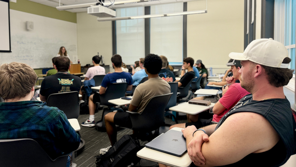 Students sitting in a classroom listening to a speaker