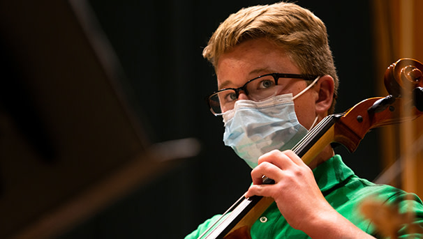 A UM music student plays a stringed instrument.