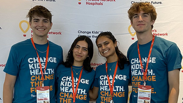 Four individuals smile for a picture