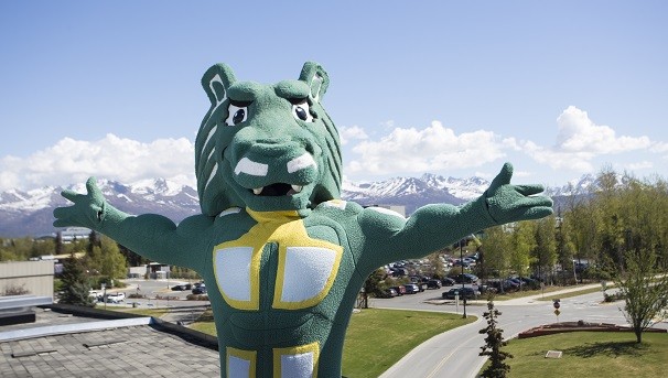 Spirit on UAA's Anchorage campus with arms outstretched in a welcoming pose