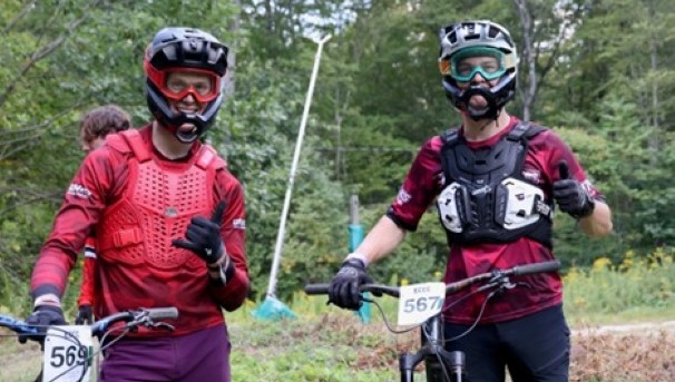 Two Cycling Club members in helmets with bikes