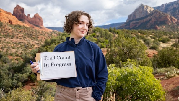 Student holding up a "Trail count in progress" sign in Sedona
