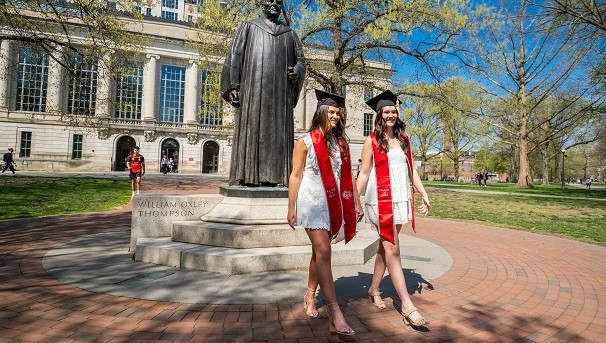 Two students posing for picture in front of the library